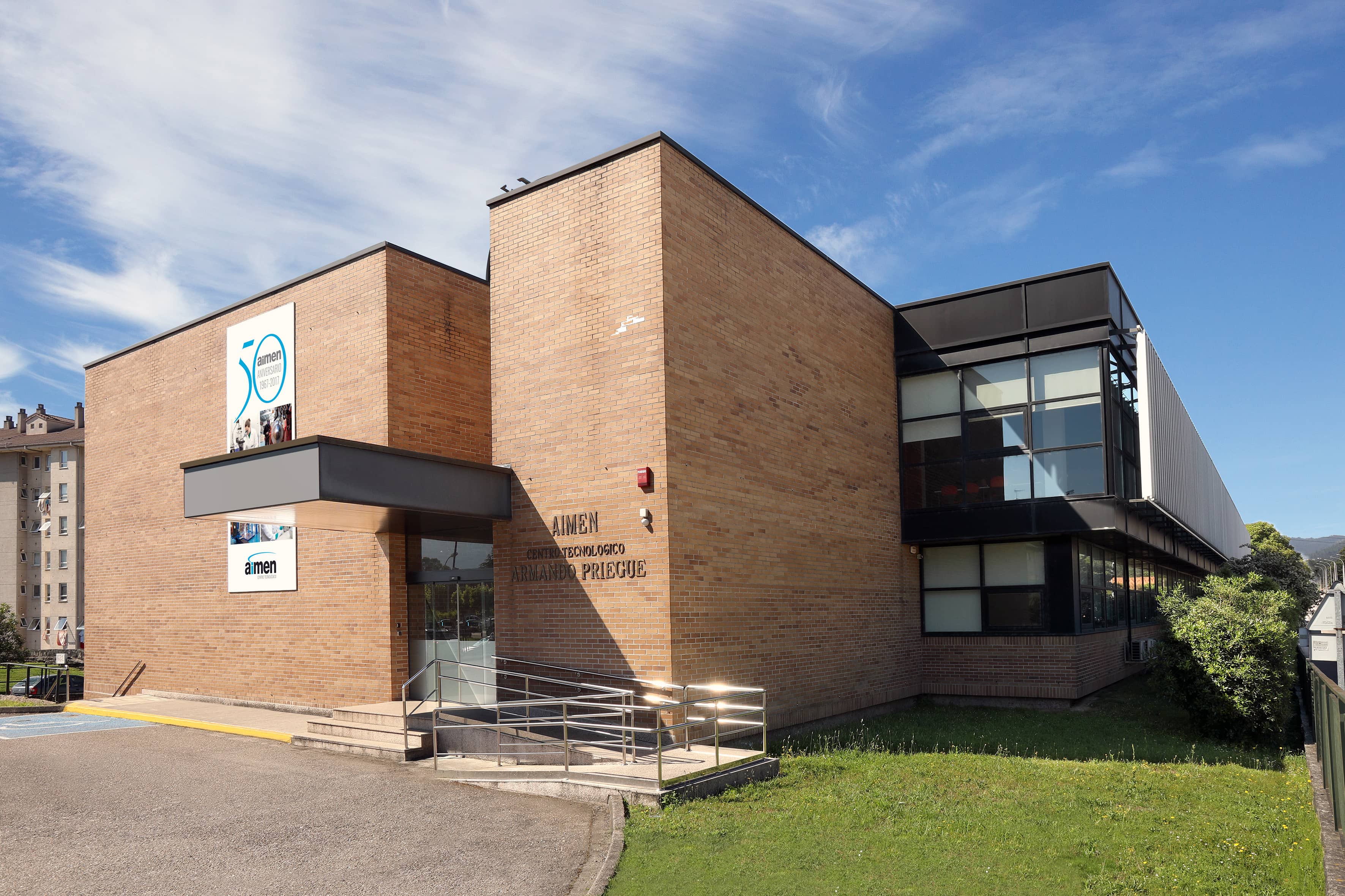 Ingeniero en taller de AIMEN manupulando maquinaria de brazos roboticos