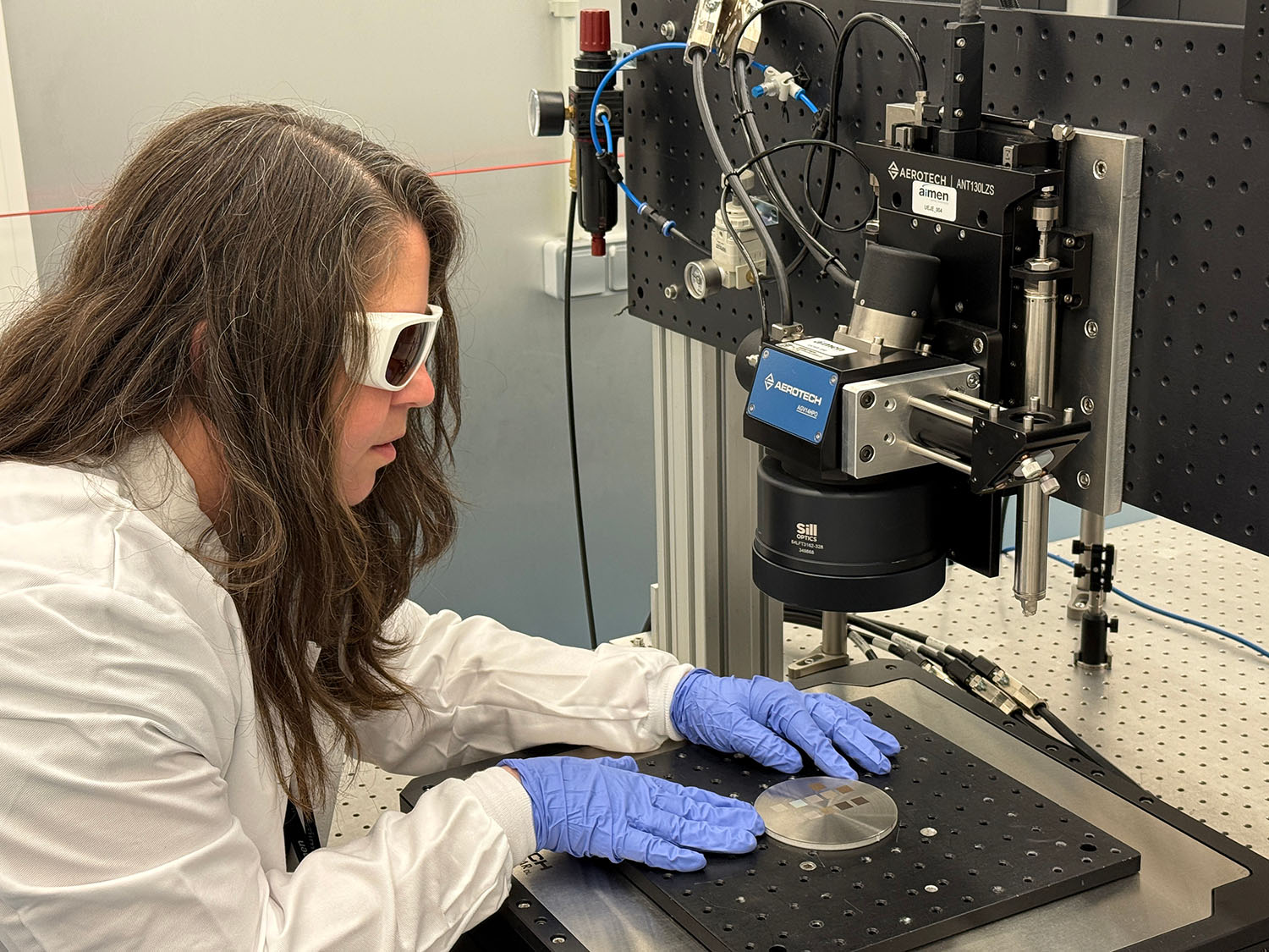 Trabajadora con gafas de soldar en maquina soldadora