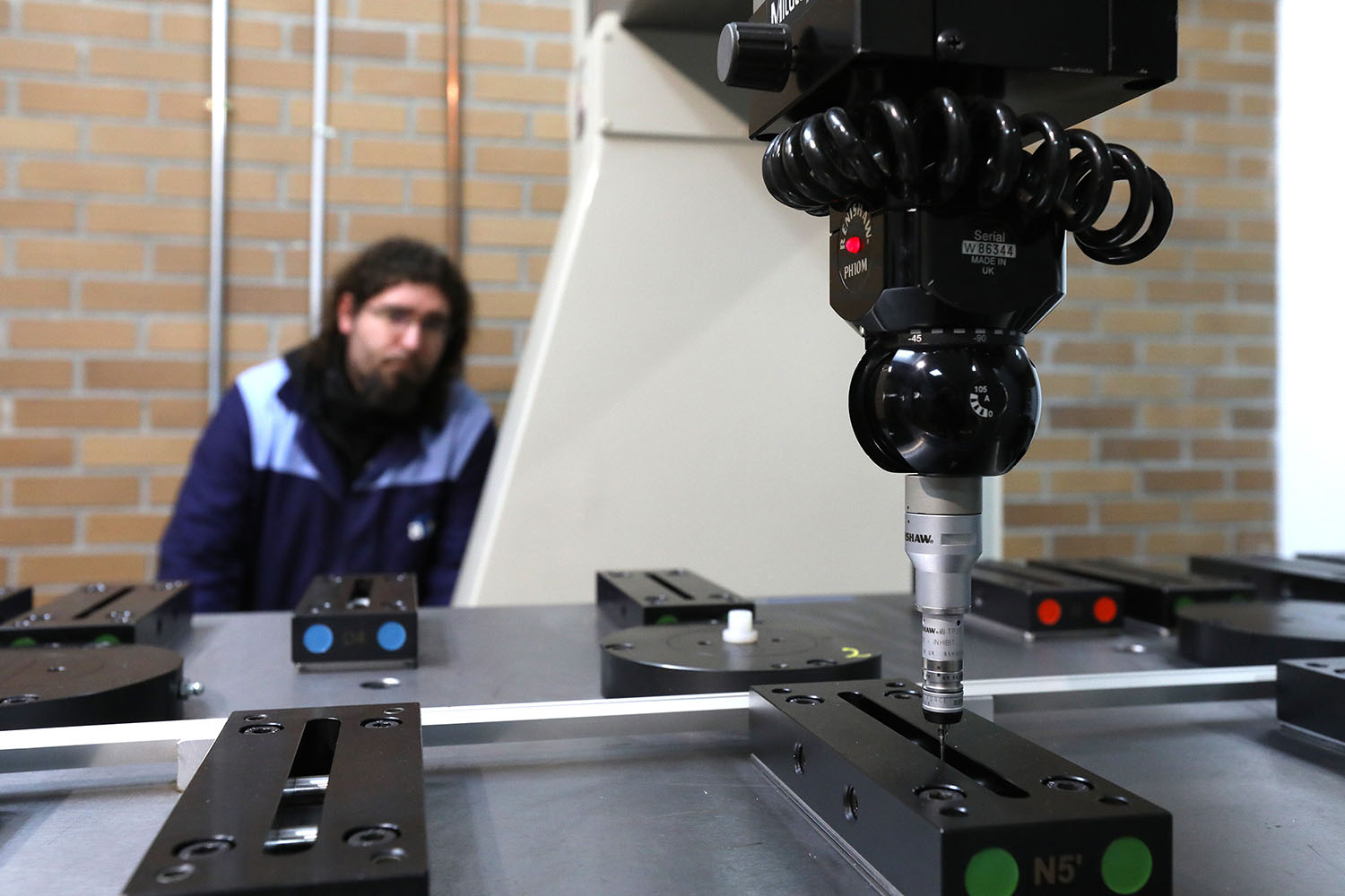 Trabajador frente a maquina de metrologia